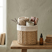 Ronde BOHO-opbergmand op een houten tafel, gevuld met kleine producten