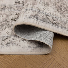 Omgeslagen hoek van het Inka vloerkleed toont de beige rand en antislip onderkant