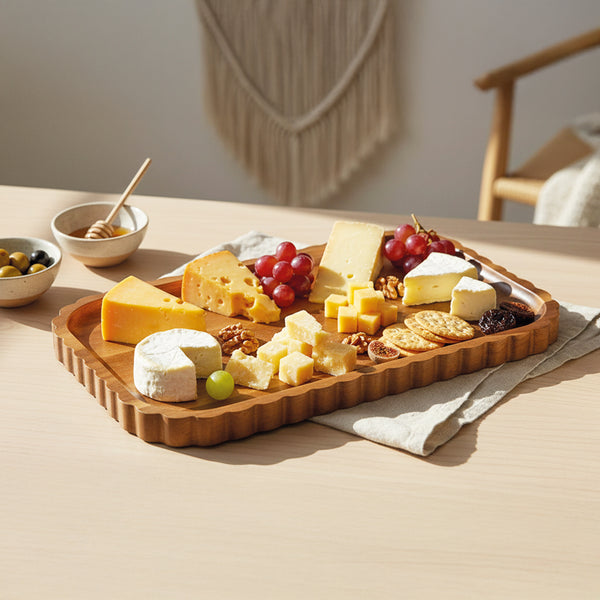 Acaciahouten serveerschaal 34x20 cm gevuld met kaas druiven en hapjes op een sfeervol gedekte tafel