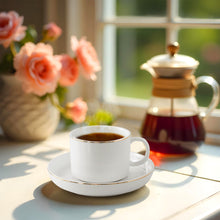 Livenza Claire kopje met koffie en schotel naast bloemen en een koffiekan