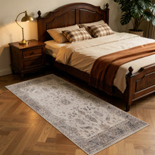 Langwerpig beige Inka 1143 vloerkleed naast een houten bed in de slaapkamer