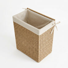 Geopende jute wasmand met zichtbare linnen voering en deksel aan de achterkant