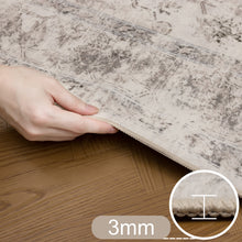 Hand tilt de rand van het beige Inka vloerkleed op met aanduiding van 3 mm dikte