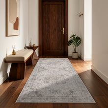 Rechthoekig beige Inka vloerkleed in een hal met houten vloer, bank en donkere deur
