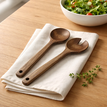 Acaciahouten serveerbestek 2 delig uit de Acora collectie op tafel als houten saladebestek